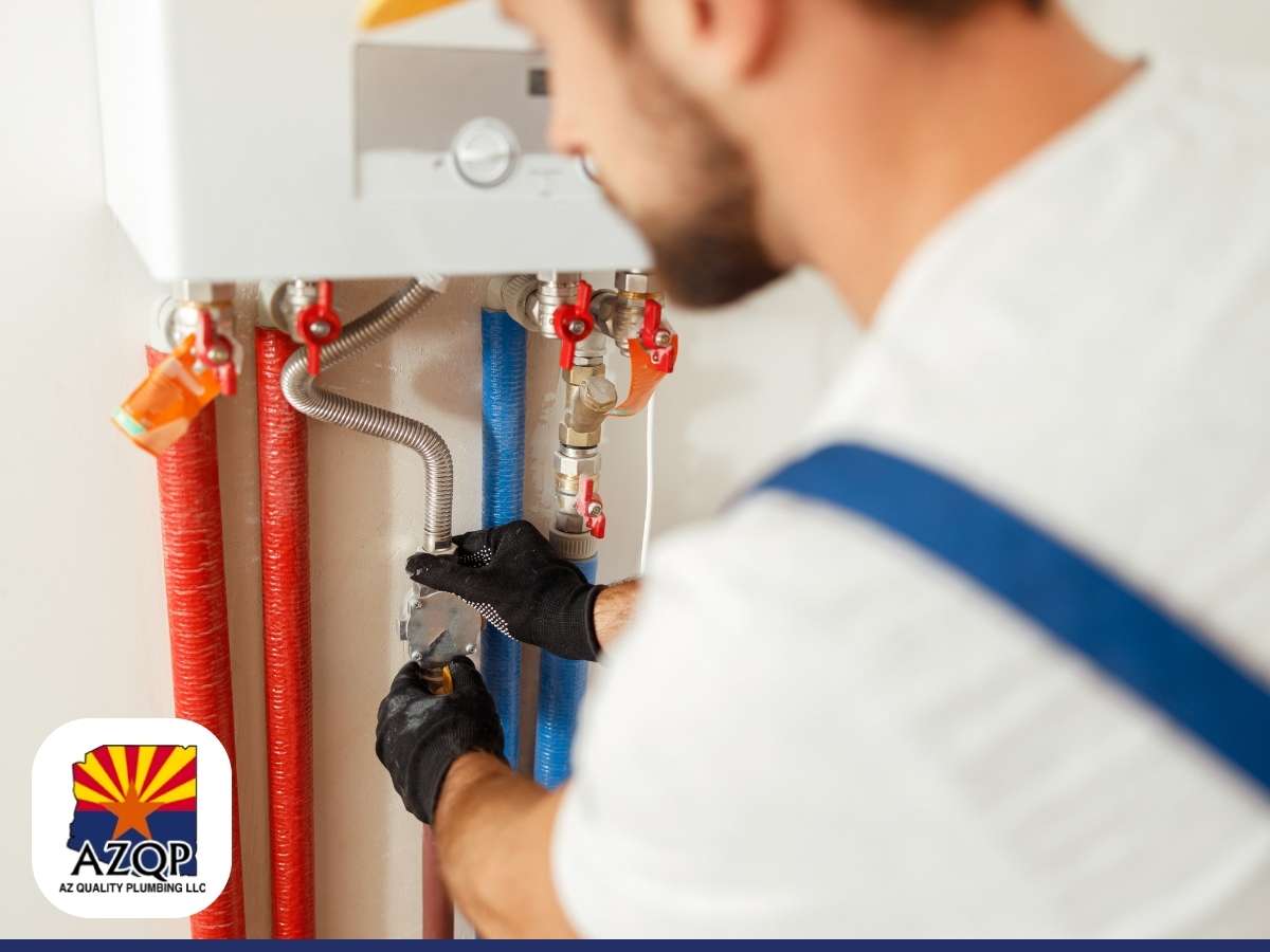 A technician is servicing a water heater, connecting pipes with a wrench.